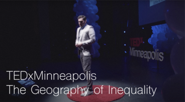 Kevin Ehrman-Solberg standing on a red circle on the TEDxMinneapolis stage